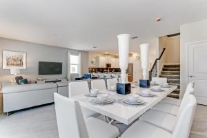 a white dining room with a white table and chairs at Storey Lake Resort - 9 Bed 5 Baths VILLA in Kissimmee