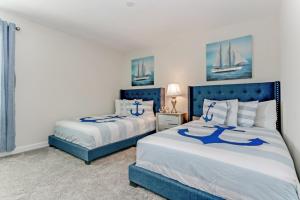 a bedroom with two beds with blue and white sheets at Storey Lake Resort - 9 Bed 5 Baths VILLA in Kissimmee