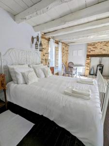 a bedroom with a large white bed with white pillows at Sous le Chateau in Jumilhac-le-Grand