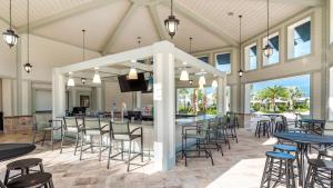 un patio cubierto con mesas y sillas y un bar en Storey Lake Resort - 5 Bed 5 Baths VILLA, en Kissimmee