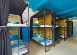 two bunk beds in a room with blue ceilings at THE PLACE Hostel & Rooftop Bar in Battambang