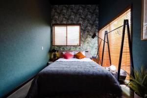 a bedroom with a bed with blue walls and a window at bamboo宮古島 in Miyako-jima