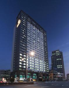 釜山的住宿－釜山皇冠海港酒店，一座高大的建筑,晚上在城市里亮着灯