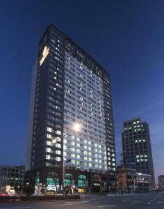 ein hohes Gebäude mit Licht in der Nacht in einer Stadt in der Unterkunft Crown Harbor Hotel Busan in Busan