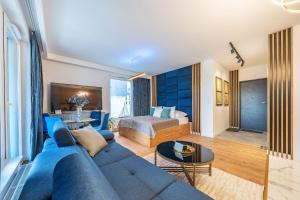 salon z niebieską kanapą i łóżkiem w obiekcie Glow Apartments, Letnica - Apartamenty Przystań Siódme Niebo w Gdańsku