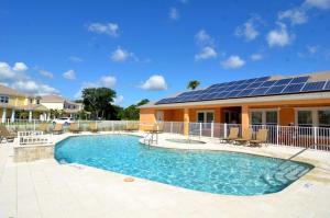 een huis met een zwembad met zonnepanelen erop bij Serenity - 3 Bed 3 Baths TOWNHOME in Orlando