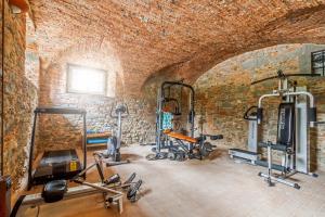 un gimnasio con varios equipos de ejercicio en una pared de ladrillo en Tenuta Guinigi Antico Borgo di Matraia - Exclusive Holidays apartments & Pool, en Lucca