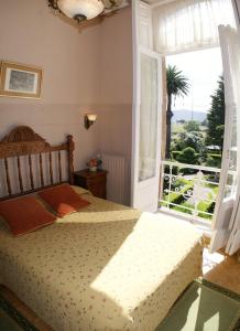 a bedroom with a bed and a large window at Villa La Argentina in Luarca