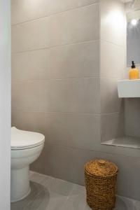 een badkamer met een toilet, een wastafel en een mand bij Mykonos be Chic Luxury Mansion in Mykonos-stad