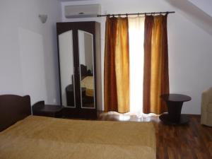 een slaapkamer met een bed en een grote spiegel bij Pensiunea Cristiana - Murighiol in Murighiol