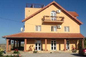 a large house with a balcony on top of it at Pensiunea Cristiana - Murighiol in Murighiol