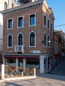 - un vieux bâtiment en briques dans une rue de la ville dans l'établissement Foscà Venice Rooms, à Venise