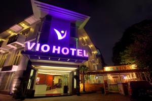 een vio hotel met een paars neonbord erop bij Vio Hotel Cimanuk Bandung in Bandung