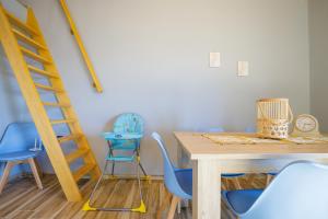 un comedor con sillas azules, una mesa y una escalera en Maritinas Apartment Sea View - Happy Rentals, en Katakolon