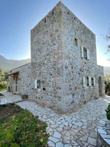 a large stone building with a stone driveway at Stylish Manihaus for a romantic adventure in Stoupa