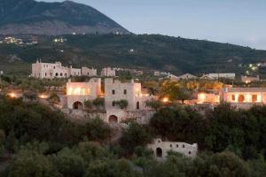 a group of buildings with a mountain in the background at Stylish Manihaus for a romantic adventure in Stoupa