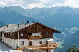 a house with a balcony and mountains in the background at Sparberhof Exklusive in Campo di Trens