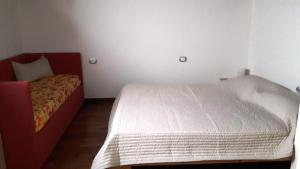 ein kleines Schlafzimmer mit einem Bett und einem roten Bettrahmen in der Unterkunft Residence Lucia 2 in Grado
