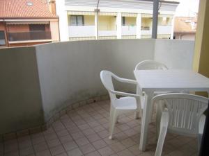 einen weißen Tisch und Stühle auf dem Balkon in der Unterkunft Residence Lucia 2 in Grado