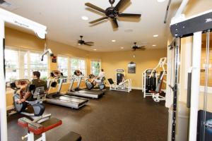 a gym with tread machines and people in it at IT289 - Vista Cay Resort - 3 Bed 2 Baths Condo in Orlando