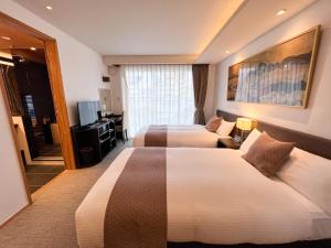 um quarto de hotel com duas camas e uma televisão em Rinn Gion Hanatouro em Quioto