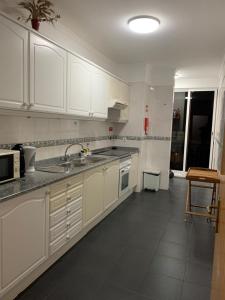 a kitchen with white cabinets and a sink at Bento Lodge by Madeira Holiday Rentals in Ribeira Brava +15 photos