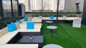 a rooftop patio with blue and white furniture and grass at base-PUSAN Serviced Apartment in Shanghai