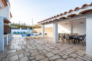 a patio with a table and chairs and a pool at Llastres in Miami Platja