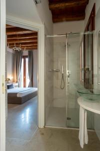 Il comprend une chambre et une salle de bains pourvue d'une douche en verre. dans l'établissement Foscà Venice Rooms, à Venise