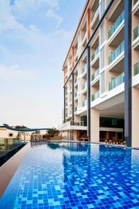 a swimming pool in front of a building at Balihai Bay Pattaya in Pattaya South