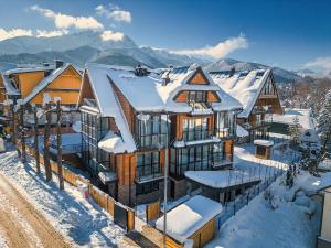 una casa cubierta de nieve en las montañas en Lipowy Dwór en Zakopane