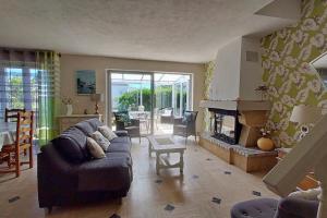 ein Wohnzimmer mit einem Sofa und einem Kamin in der Unterkunft Maison côte sauvage classement 3 in Quiberon