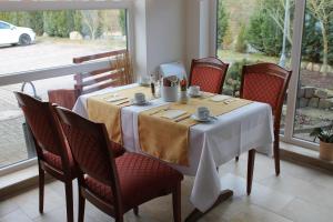 a table with chairs and a white table cloth on it at Lindenhotel Stralsund in Stralsund