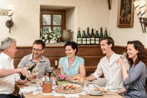 a group of people sitting around a table drinking wine at Gästehaus Turm Wachau in Weissenkirchen in der Wachau
