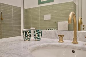 Un baño con un lavabo con dos jarrones encima. en RELAIS DEI GOTI, en Roma