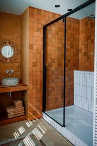 una doccia con porta in vetro in bagno di Plein 11 a Maarkedal