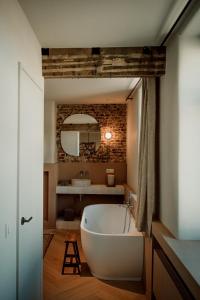 La salle de bains est pourvue d'une baignoire blanche et d'un miroir. dans l'établissement Plein 11, à Markedal