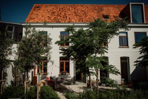 una gran casa blanca con techo rojo en Plein 11 en Maarkedal