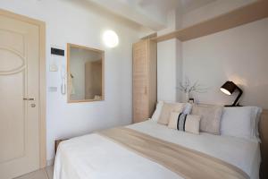 um quarto com uma cama branca e um espelho em Hotel Teti em Bellaria-Igea Marina