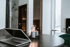 a laptop computer sitting on a table with candles at Sniegi design cabin with sauna in Madona
