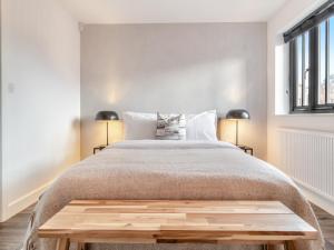 a bedroom with a bed with a wooden bench at the end of it at Vancouver View in King's Lynn