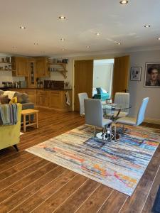 a living room with a table and chairs and a kitchen at Bridge House Apartment. Luxury and cosy self contained apartment. in South Luffenham