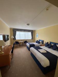 a hotel room with two beds and a desk at Tiverton Hotel Lounge & Venue formally Best Western in Tiverton