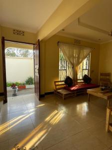een kamer met een bed en een groot raam bij Wonders Hostel in Arusha