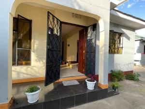 a front door of a house with potted plants at Wonders Hostel in Arusha
