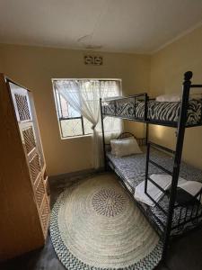 a bedroom with two bunk beds and a large rug at Wonders Hostel in Arusha