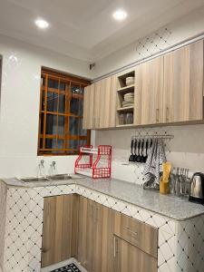 cocina con armarios de madera y encimera en Regency Stays en Eldoret