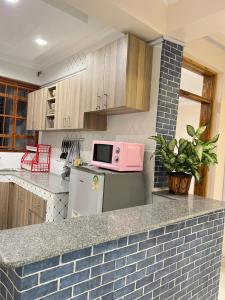 a kitchen with a counter top with a pink microwave at Regency Stays in Eldoret