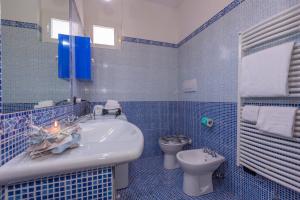 ein blau gefliestes Bad mit einem Waschbecken und einem WC in der Unterkunft La Casa Al Sole sea view 400mt from sea - Happy Rentals in Cervo