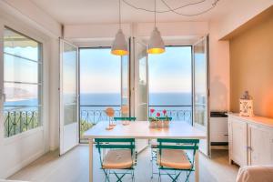 eine Küche mit einem Tisch und Stühlen mit Meerblick in der Unterkunft La Casa Al Sole sea view 400mt from sea - Happy Rentals in Cervo